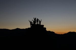 People on top of a mountain with a sunset